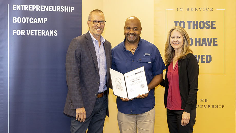 MU staff Greg Bier, executive director of entrepreneurship programs, left, and Kelly Mattas, senior program/project support coordinator, presented Air Force veteran Keith Andrews .