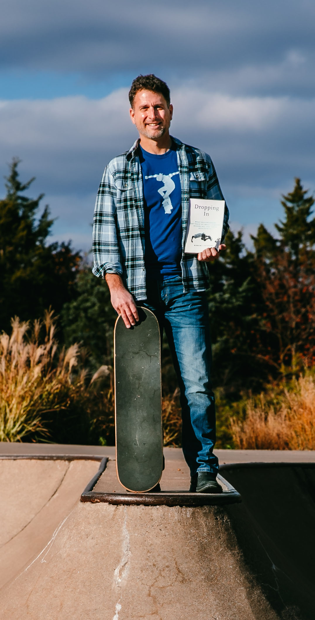 Rob Petrone stands with a skateboard