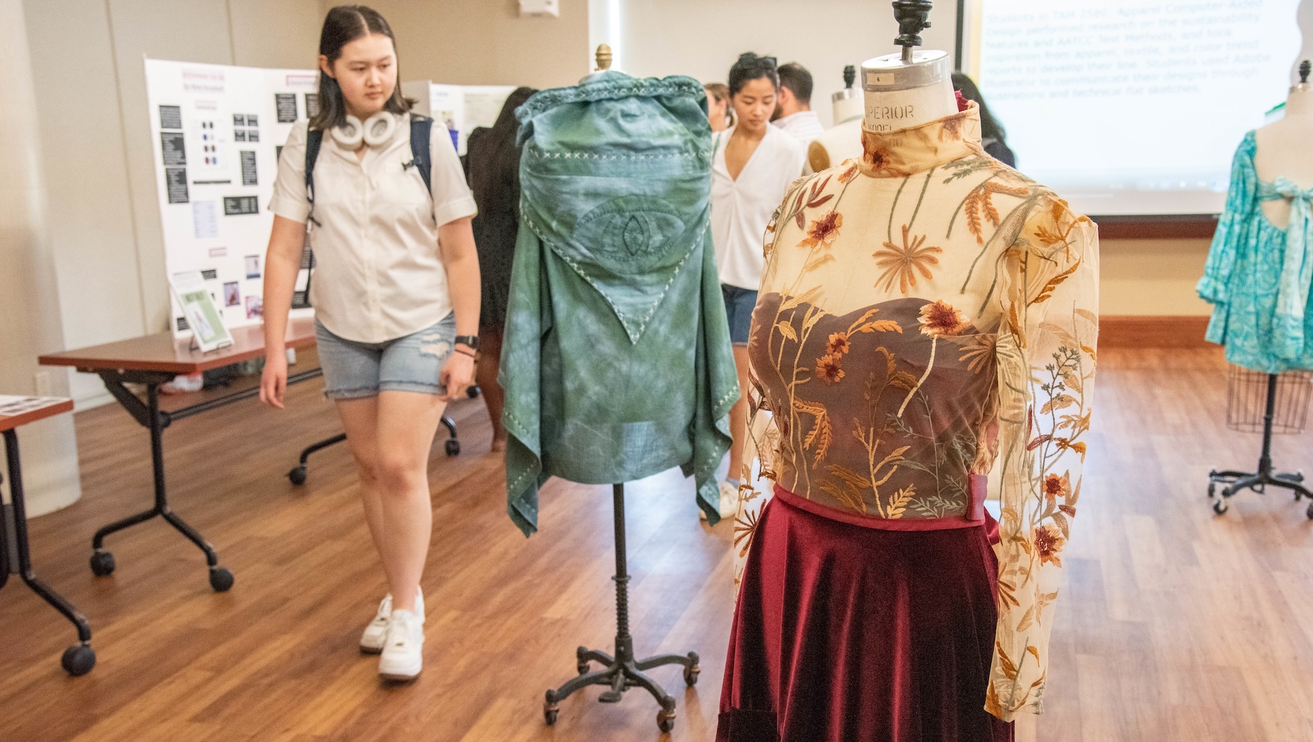A student views fashion, including a dress, during a Show Me Research Week 2023 fashion exhibit.