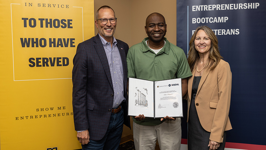 Veteran Dave Richards, center, receives his certificate of completion from Greg Bier and Kelly Mattas.