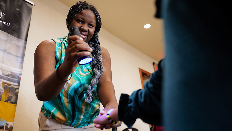 Exhibiter holds a flashlight on a bracelet