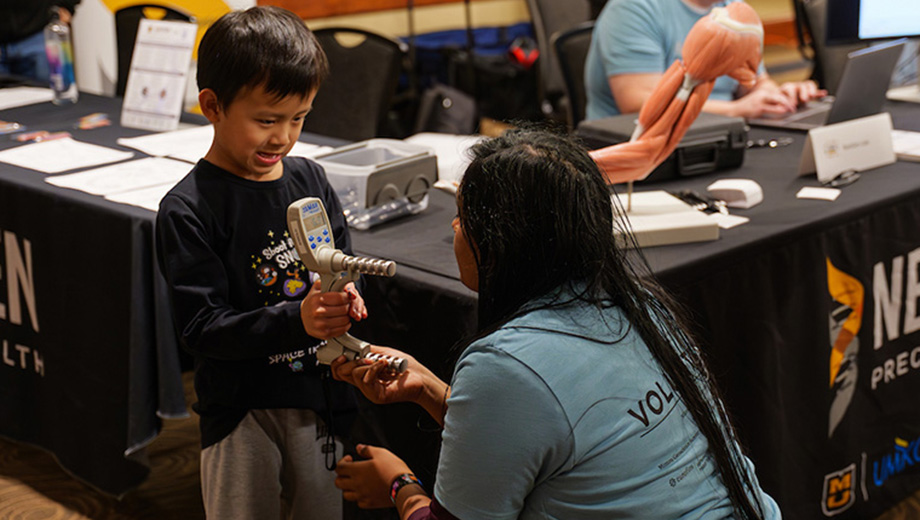 Boy tries a device at the NextGen booth