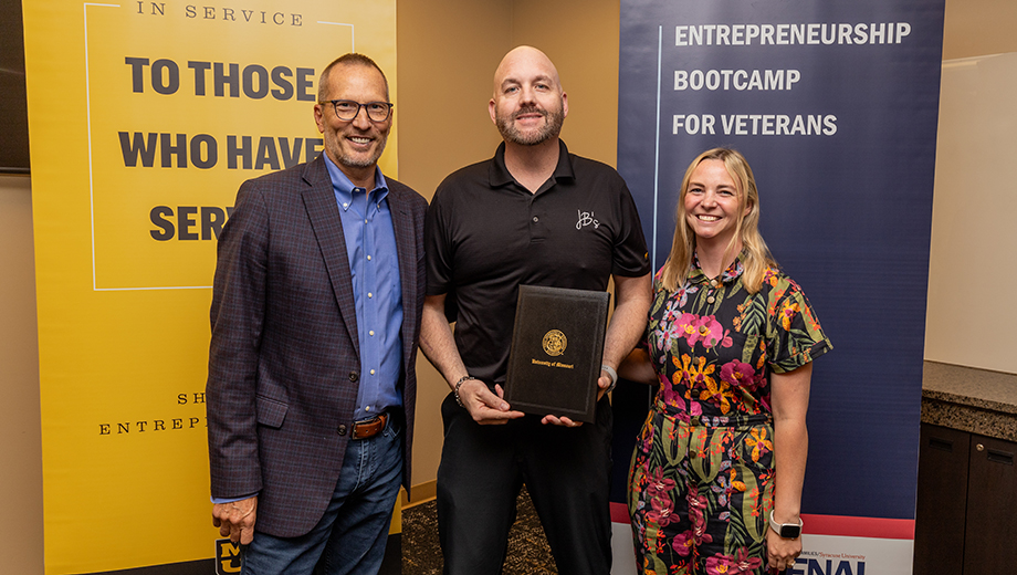 EBV organizers present a certificate to a graduate.