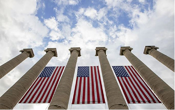 image of MU's columns with three U.S. flags hanging from them