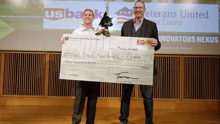 Jack Murray, his dog Heidi and Greg Bier pose with a large $15,000 check.