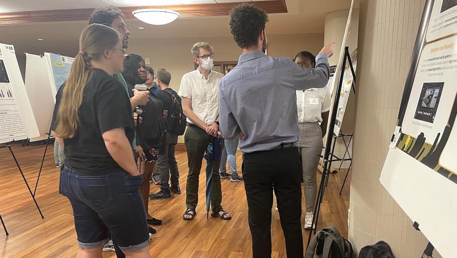 Students discuss a research poster during the the Summer Undergraduate Research and Creative Achievements Forum on July 28 in Memorial Student Union.