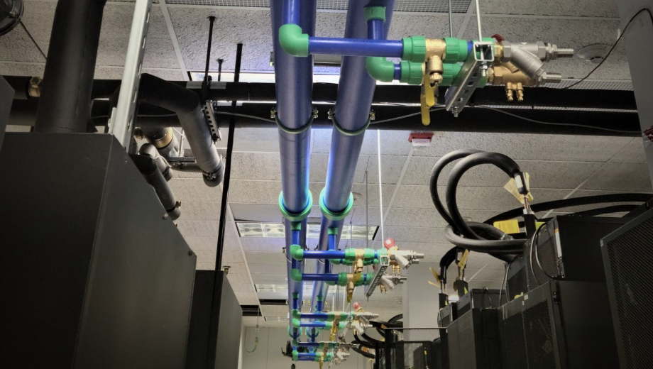 Two blue pipes run parallel to each other with green pipe connectors. 
