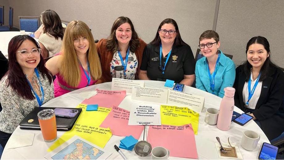 Conference presenters share a table.