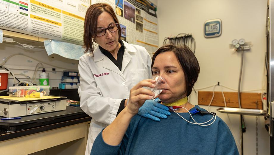 Teresa Lever, left, has her healthy study volunteer drink water.