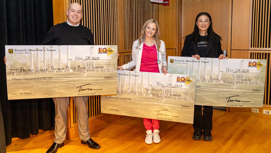 Parker Owens, Lauren Compton and Jia Wu pose with giant checks that show the amount of money they won.