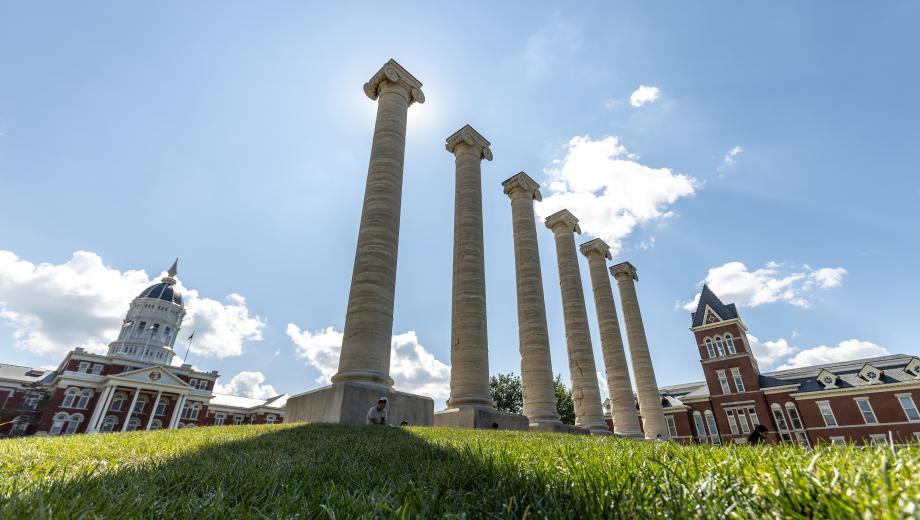 Photo of the Columns at the University of Missouri with blue sky behind them.