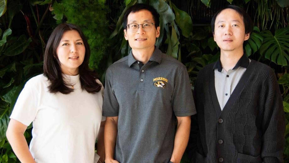 Three members of Bioinformatics and Analytics Core in front of wall of plants.