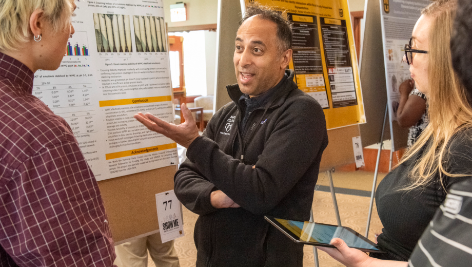 Dr. Tosh talks to some students about their research at Show Me Research Week.