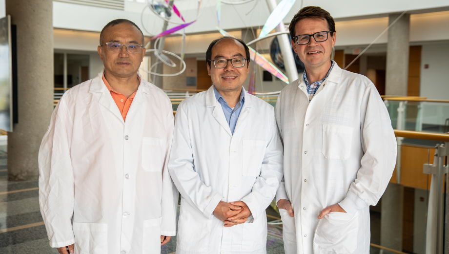 Three scientists pose for portrait in lab coats