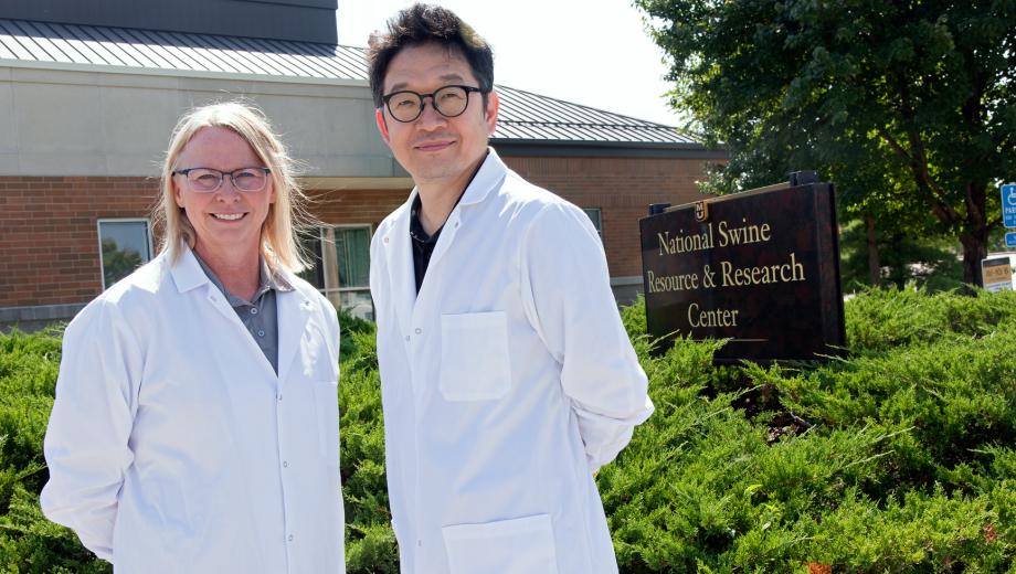 Kristin Whitworth and Kiho Lee pose in front of the newly-expanded National Swine Resource and Research Center. 