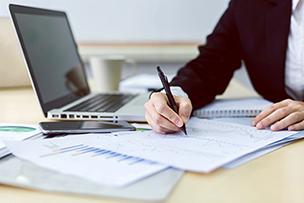 person with laptop and paperwork