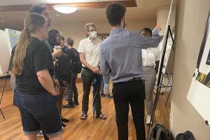 Students discuss a research poster during the the Summer Undergraduate Research and Creative Achievements Forum on July 28 in Memorial Student Union.