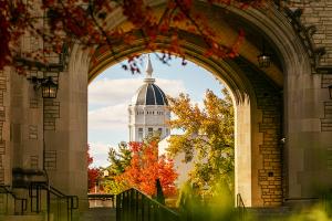 Jesse Hall with fall leaves viewed through the Memorial Union arch.