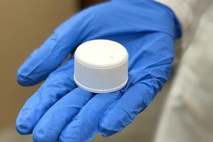 Gloved hand holding venting cap