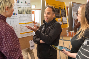 Dr. Tosh talks to a student about their poster at Show Me Research Week
